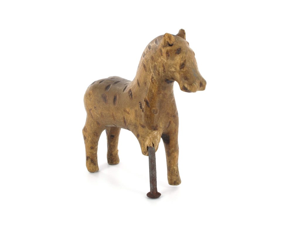 A wooden toy horse with a broken leg